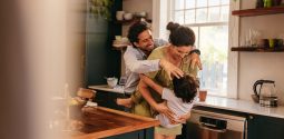 Parents playing with their son in the kitchen. Two happy parents laughing and having fun with their young son at home. Family of three spending some quality time together.