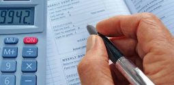 Hand with a pen over an accounts book